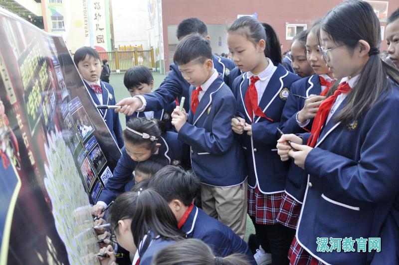 活动中学生们纷纷在学习宪法活动展板上签名.jpg