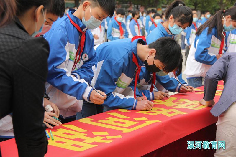 学生代表在横幅上郑重签上自己的名字.jpg